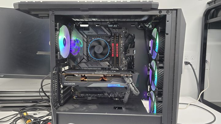 Open desktop computer showing motherboard, graphics card and cooling fans