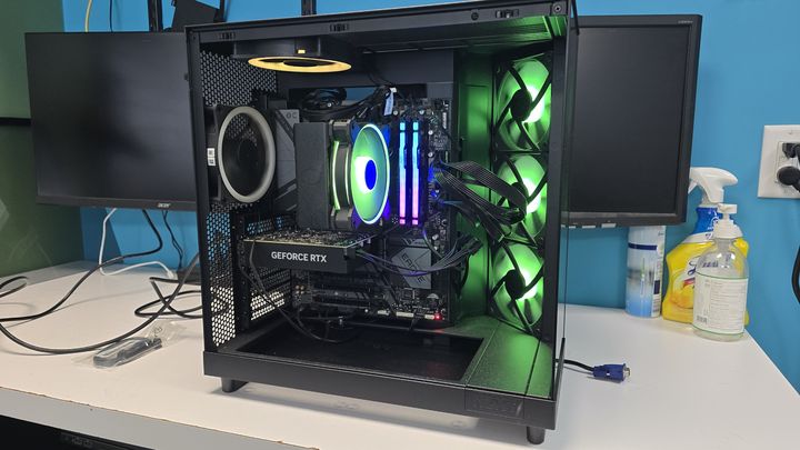 Black desktop tower with green ring lighting on its fans