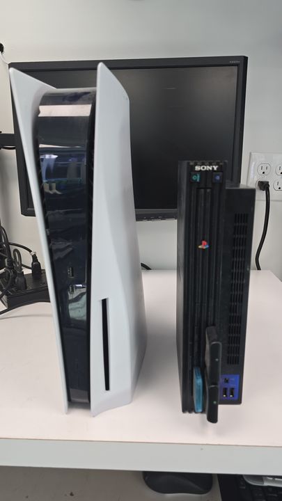 Front view of PlayStation 5 and PlayStation 2 consoles on the workbench