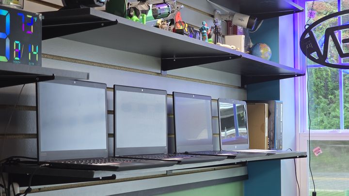 A row of laptops displayed inside the computer repair shop