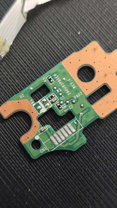 A small green circuit board held above the workbench